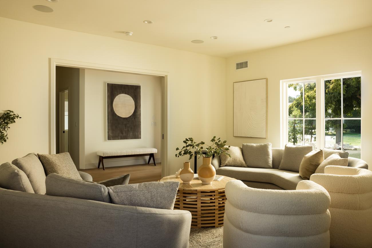 Living room with curved boucle chairs and layered neutral textiles