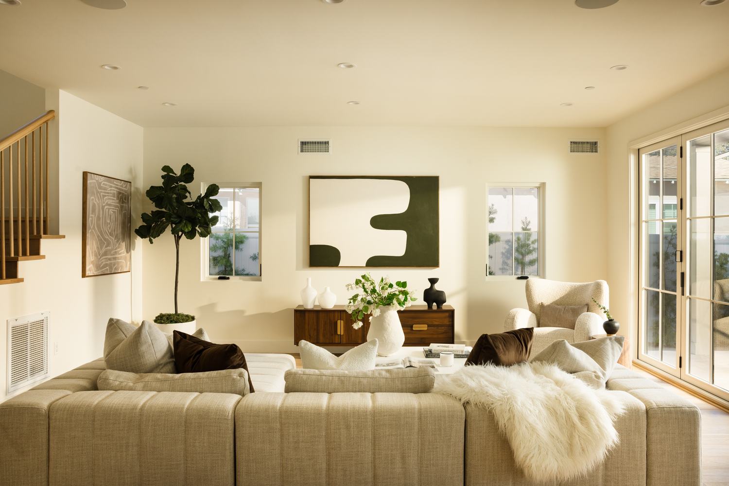 Living room filled with afternoon light, cream sectional and gallery wall